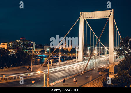 Di notte il traffico di tempo oltre il ponte Elisabetta. Si attraversa il fiume Danubio e la collega Buda e Pest insieme. Budapest, Ungheria. Foto Stock