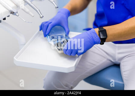 Gli strumenti del dentista. Medico apre stiril set di strumenti dentali in dental clinic. Foto Stock