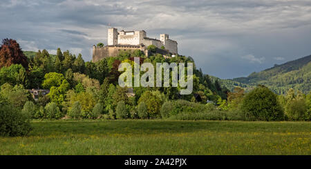 La storica fortezza di Hohensalzburg vista dal lato sud che si affaccia su un prato di fiori e le impressionanti Festungsberg a Salisburgo, Austria Foto Stock