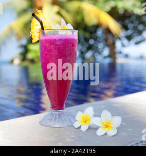 Dragon succo di frutta. Hotel riposo. Dragon frutto shake. Cocktail fresco e fiori di frangipani in piscina. Un drink rinfrescante sulla spiaggia. Foto Stock