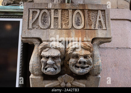 Scowling intagliato si affaccia su un edificio nel centro di Helsinki, Finlandia Foto Stock