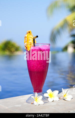 Dragon succo di frutta. Hotel riposo. Dragon frutto shake. Cocktail fresco e fiori di frangipani in piscina. Un drink rinfrescante sulla spiaggia. Foto Stock