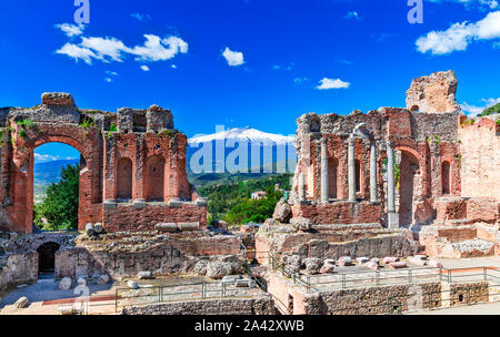 Taormina, Sicilia, Italia: il Teatro Greco di Taormina con il fumo del vulcano Etna in background, in un bel giorno di estate Foto Stock