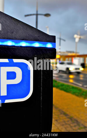 Il traffico in movimento durante la notte nella parte anteriore del parcometro Foto Stock