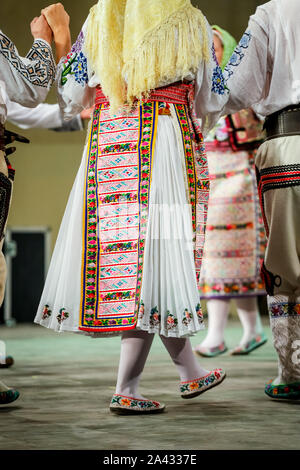 Close up di gambe di giovani donne rumene ballerino in tradizionale costume folkloristico. Il folklore della Romania Foto Stock