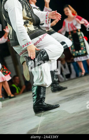 In prossimità delle gambe del giovane rumeno ballerino maschio nel tradizionale costume folkloristico. Il folklore della Romania Foto Stock