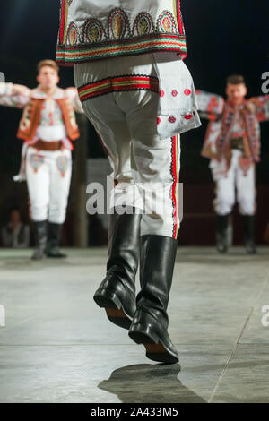 In prossimità delle gambe del giovane rumeno ballerino maschio nel tradizionale costume folkloristico. Il folklore della Romania Foto Stock