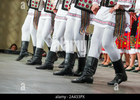 In prossimità delle gambe del giovane rumeno ballerino maschio nel tradizionale costume folkloristico. Il folklore della Romania Foto Stock