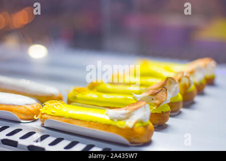 Deliziosa torta fresca eclairs con crema per la vendita sul contatore Foto Stock