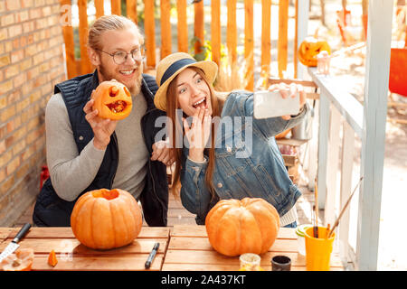 I giovani adulti donna e uomo prendendo selfie con la zucca Foto Stock