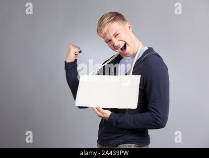 Overjoyed uomo presentando cartello vuota. Foto Stock