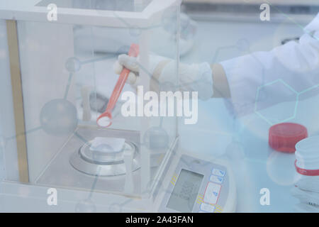 Ponderazione di acido ascorbico in laboratorio chimico. Foto Stock