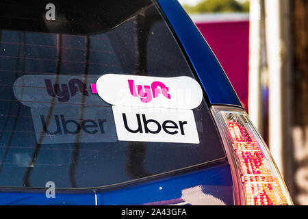 Oct 10, 2019 Mountain View / CA / STATI UNITI D'AMERICA - Lyft e UBER adesivi sul lunotto posteriore di un veicolo che offre corse in San Francisco Bay Area Foto Stock