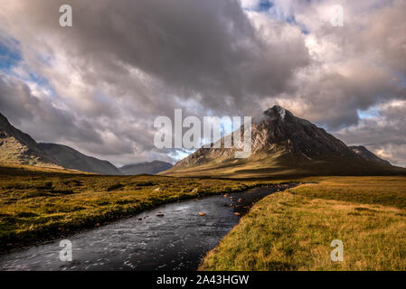 The Glen Etive fiume conduce al Golden la luce del mattino sulla montagna piramidale picco di Buachaille Etive Mòr, Glencoe, Highlands scozzesi Foto Stock