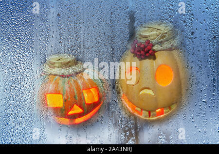 Creepy zucche di Halloween guardare fuori dalla finestra dalla strada Foto Stock