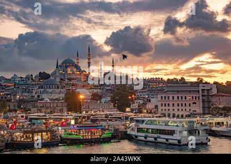 Tramonto burrascoso ad Istanbul in Turchia. I caffè e i ristoranti la linea di riva in barche. Gabbiani e corvi overhead di cerchio come il tramonto sulla città. Foto Stock