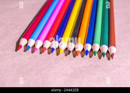 Gruppo colorato di pastelli/matita colorata posa sul tavolo. Foto Stock