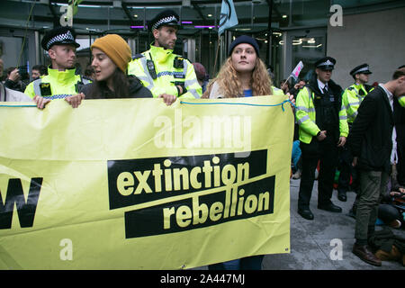 Londra, Regno Unito. Undicesimo oct, 2019. Gli attivisti del clima dalla ribellione di estinzione tenere un banner di grandi dimensioni come protestano al di fuori di BBC Broadcasting House come l'edificio era stato bloccato verso il basso evitando che i giornalisti di lasciare. Estinzione della ribellione hanno accusato la British Broadcasting service di polarizzazione e il silenzio oltre il problema del cambiamento climatico Credito: SOPA Immagini limitata/Alamy Live News Foto Stock