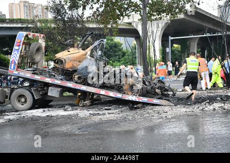 Gli operatori sanitari puliti in corrispondenza della zona dove la combustione spontanea di un auto è accaduto nella città di Chengdu, a sud-ovest della Cina¯s nella provincia di Sichuan, 5 agosto Foto Stock