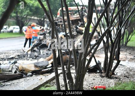 Gli operatori sanitari puliti in corrispondenza della zona dove la combustione spontanea di un auto è accaduto nella città di Chengdu, a sud-ovest della Cina¯s nella provincia di Sichuan, 5 agosto Foto Stock