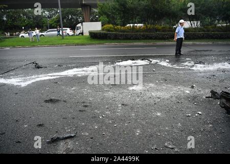 Gli operatori sanitari puliti in corrispondenza della zona dove la combustione spontanea di un auto è accaduto nella città di Chengdu, a sud-ovest della Cina¯s nella provincia di Sichuan, 5 agosto Foto Stock