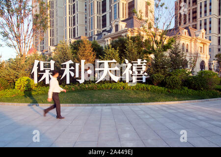 --FILE--un residente locale passeggiate passato un appartamento progetto di poli sviluppi e aziende Group Co., conosciuto anche come Poly Real Estate, nella città di Dalian, Foto Stock