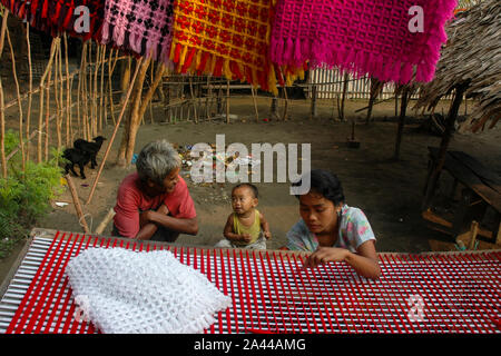 Una ragazza di etnia comunità Rakhain tessitura stoffa con un tradizionale handloom. Kuakata, Patuakhali, Bangladesh. Foto Stock