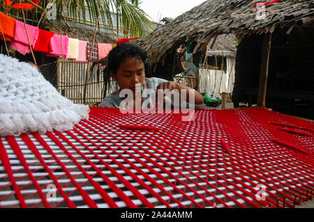 Una ragazza di etnia comunità Rakhain tessitura stoffa con un tradizionale handloom. Kuakata, Patuakhali, Bangladesh. Foto Stock