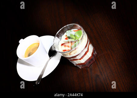 Il caffè e il deserto su una tabella con candela Foto Stock