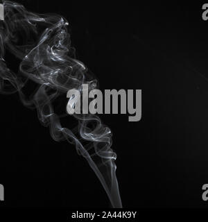 Abstract il fumo bianco volute pattern su sfondo nero Foto Stock