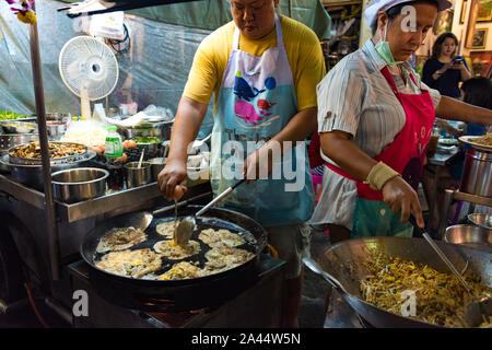 Hua Hin, Tailandia - 28 dicembre 2015: l uomo e la donna che fa il pad tradizionale tailandese e oyster omelette su Hua Hin notte mercato alimentare. Autentica della Thailandia Foto Stock