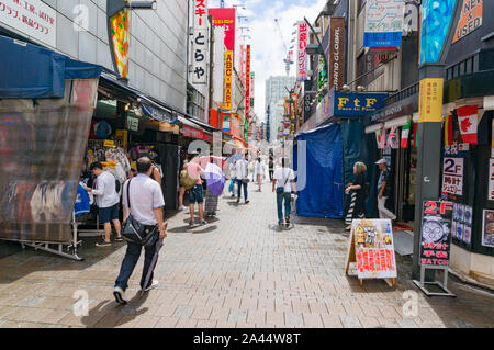 Tokyo, Giappone - 29 agosto 2016: mercato Ameyoko vicolo, street con il venditore si spegne e la folla di gente. Banner in giapponese pubblicizza orologi, custom mad Foto Stock