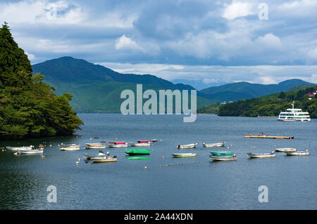 Hakone, Giappone - 3 Settembre 2016: colorate barche da pesca con le montagne sullo sfondo sulla caldera Lago Ashi. Ashi lake è un vulcano Crater Lake in M Foto Stock