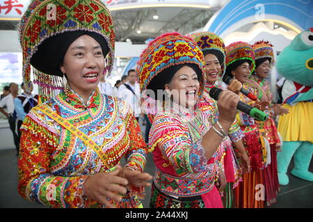 Etnica cinese di persone in costumi tradizionali eseguire durante la cerimonia di apertura di Creative 2019 Esposizione culturale nella città di Kunming, southw Foto Stock