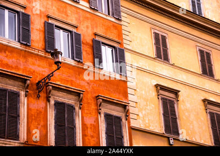 Edifici romani nel cuore del centro storico con persiane in legno e dettagli eleganti, Italia. Foto Stock