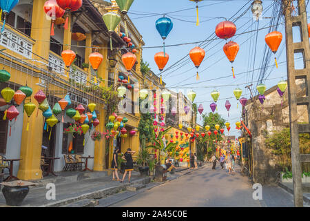 HOI AN, VIETNAM - 24marzo 2017: colorata architettura e lanterne lungo le strade di antica città di Hoi An durante il giorno. La gente può essere visto. Foto Stock