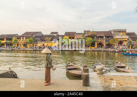 HOI AN, VIETNAM - 24marzo 2017: Architettura e barche in antica città di Hoi An durante il giorno lungo il fiume Thu Bon. Un sacco di persone può essere visto. Foto Stock