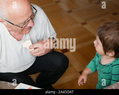 Un ragazzo sta giocando con il nonno. Nonno e nipote si diverte. giocato un artigianale di gioco di bordo con il nonno. Foto Stock