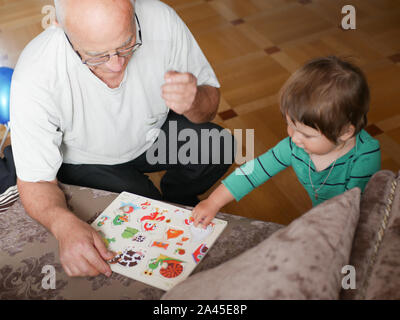 Un ragazzo sta giocando con il nonno. Nonno e nipote si diverte. giocato un artigianale di gioco di bordo con il nonno. Foto Stock