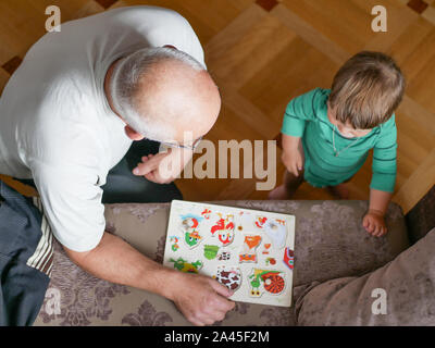 Un ragazzo sta giocando con il nonno. Nonno e nipote si diverte. giocato un artigianale di gioco di bordo con il nonno. Foto Stock