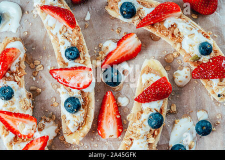 Banana Split con fragole, mirtilli, burro di mandorla e miele Foto Stock