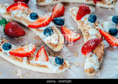 Banana Split con fragole, mirtilli, burro di mandorla e miele Foto Stock