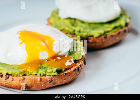 Uovo affogato e purea di Avocado su pane tostato Foto Stock