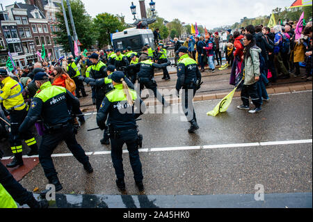 Amsterdam, Paesi Bassi. Xii oct, 2019. Blocco di poliziotti manifestanti durante la dimostrazione.centinaia di estinzione della ribellione attivisti bloccato uno dei ponti importanti in Amsterdam, il Blauwbrug nel centro della città in modo che il governo olandese è in grado di riconoscere la crisi climatica. Credito: SOPA Immagini limitata/Alamy Live News Foto Stock