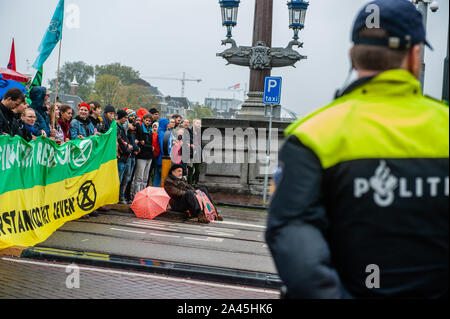 Amsterdam, Paesi Bassi. Xii oct, 2019. Manifestanti tenere un banner durante la dimostrazione.centinaia di estinzione della ribellione attivisti bloccato uno dei ponti importanti in Amsterdam, il Blauwbrug nel centro della città in modo che il governo olandese è in grado di riconoscere la crisi climatica. Credito: SOPA Immagini limitata/Alamy Live News Foto Stock