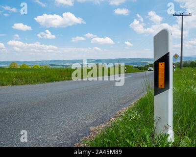 Delineatore sulla strada di un paese Foto Stock