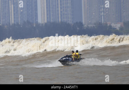 Surfisti cavalcare un onda sul Fiume Qiantang in Hangzhou, Oriente Cina¯s nella provincia di Zhejiang, 16 settembre 2019. Foto Stock