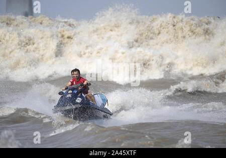 Surfisti cavalcare un onda sul Fiume Qiantang in Hangzhou, Oriente Cina¯s nella provincia di Zhejiang, 16 settembre 2019. Foto Stock