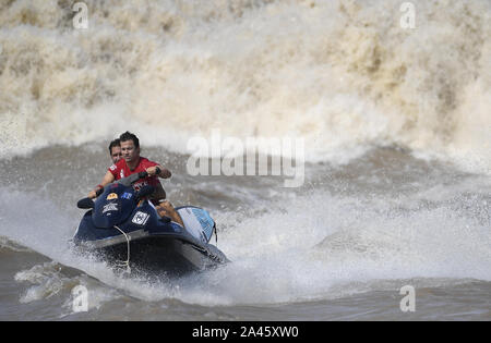 Surfisti cavalcare un onda sul Fiume Qiantang in Hangzhou, Oriente Cina¯s nella provincia di Zhejiang, 16 settembre 2019. Foto Stock