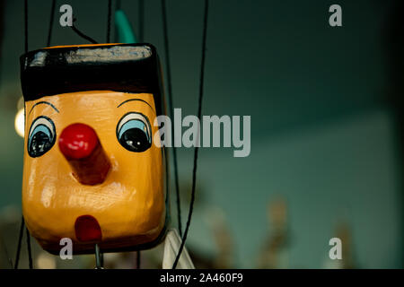 Primo piano su un grazioso stand in legno d'epoca Pinocchio su appendiabiti. Il famoso personaggio di un romanzo per bambini dello scrittore italiano Carlo Collodi. Foto Stock